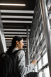© Rabizo Anatolii - Business woman with backpack and smartphone waiting for departure. Asian girl traveler with luggage heads towards boarding gate.