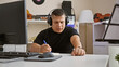 © Krakenimages.com - Talented young latin musician engrossed in crafting a soulful song at his cozy music studio, headphones on, effortlessly composing on his computer.