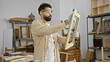 © Krakenimages.com - A young bearded man cleans a wooden frame carefully in a well-organized carpentry workshop.