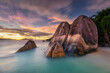© Erika Valkovicova - Dreamy sunset with dramatic clouds on a tropical beach with granite rocks, turquoise sea and palm trees on La Digue island in Seychelles, Africa