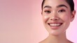 © Ananncee Media - An Asian woman smiles brightly, showcasing her flawless makeup on a pink background