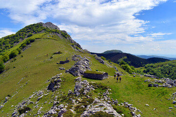 Wall Mural - Some hikers walking along the Larrano col in the Urkiola Natural Park. Basque Country. Spain