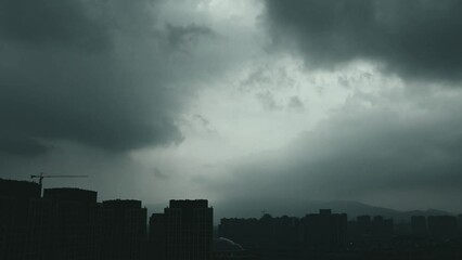 Wall Mural - Time lapse of dark clouds over a city