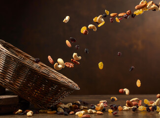 Wall Mural - Dried fruits and nuts fall in basket.