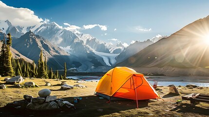A vibrant orange tent stands out in a serene mountainous landscape as the sun sets, bringing a day of adventure to a tranquil end. 