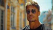 © Maxim Borbut - A confident man in a black shirt and sunglasses stands on a street in an urban setting