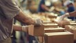 © JK_kyoto - A close up of a volunteer packing meals at a nonprofit organization, each box carefully filled with essentials, with a blurry background suggesting a busy and dedicated team