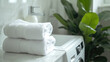 © vefimov - Stack of white towels placed on top of a washing machine