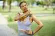 © DragonImages - Woman in sportswear cooling down after an outdoor workout, using a towel to wipe sweat off her neck