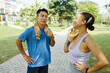 © DragonImages - Man and woman in athletic wear relaxing and talking after an outdoor exercise routine in a park