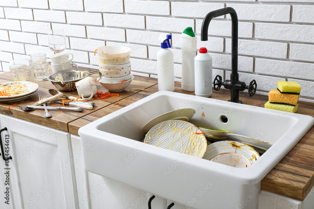 Wooden counter with ceramic sink and dirty dishes in kitchen