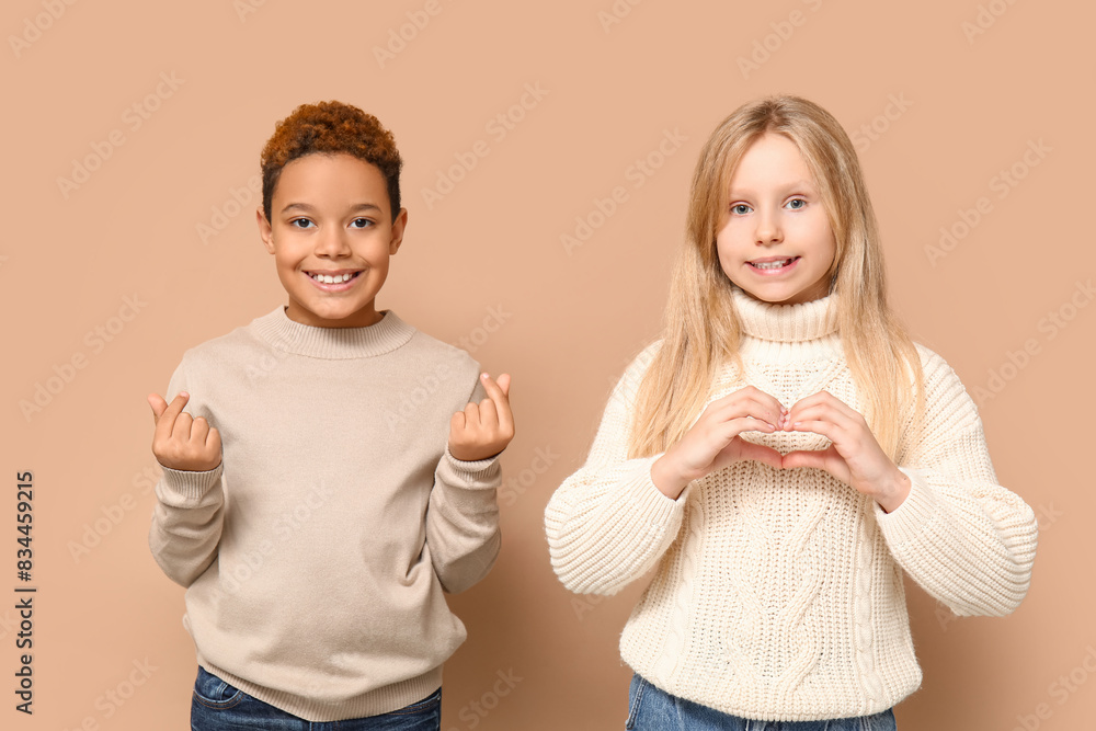 Cute little children showing heart gesture on brown background. Valentine's day celebration
