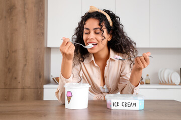 Wall Mural - Beautiful young African-American woman with baskets of ice cream on table in kitchen