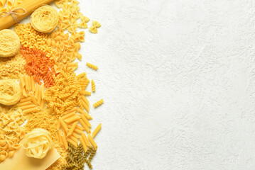 Wall Mural - Different tasty uncooked pasta on light background