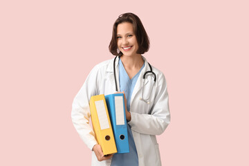 Canvas Print - Beautiful female doctor with folders on pink background