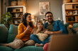 © La Famiglia - Smiling Caucasian family sitting on the couch and watching a comedy on the TV