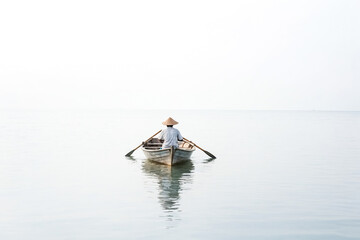 Wall Mural - A Man Rows a Boat on a Calm Sea