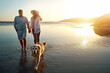© Reese2000/peopleimages.com - Beach, water and couple with dog at sunset for outdoor adventure, travel and vacation together. Man, woman and holding hands with furry pet by ocean for love, support and summer holiday in Cancun