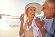 © peopleimages.com - Senior, happy couple and beach with laugh in sunset for funny joke or bonding together in nature. Man, woman or lovers with smile for outdoor sunshine, summer or holiday by water, sea or ocean coast