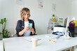 © Alfonso Soler - Professional woman using smartphone at work