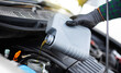 © My Ocean studio - Close up photo of car mechanic or repairman is changing engine oil. Refueling and pouring oil into the engine motor car. Transmission and maintenance gear