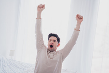 Canvas Print - Photo of young sleepy man waking up morning in comfortable flat white day light room interior indoors