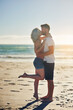 © peopleimages.com - Love, couple and kiss at beach on holiday, travel or summer vacation outdoor in nature. Romance, man and woman at sea together for connection, support and commitment to healthy relationship by ocean