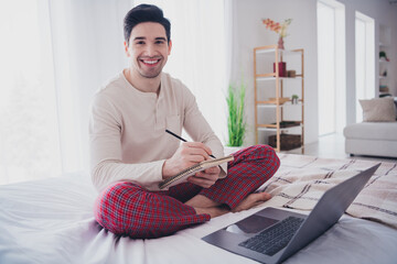 Poster - Photo of attractive man in nightwear studying from home sitting on bed in white room indoors