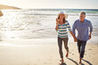 © peopleimages.com - Mature couple, holding hands and portrait at ocean on holiday, travel and summer sunshine on vacation for love in nature. Happy man, woman and beach for adventure, funny and laughing on date outdoor