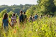 © mattegg - A group of young students walks through a meadow filled with wildflowers, on a sunny day