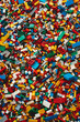 © grey - A chaotic yet colorful jumble of toy bricks, tightly packed to fill the entire frame. The bricks come in various sizes and an array of colors including red, blue, green, yellow, and white,