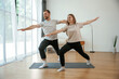 © standret - Warrior asana. Man and woman are doing yoga exercises at home