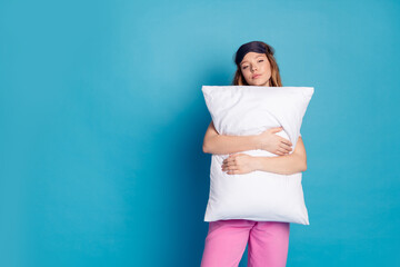 Sticker - Photo of tired lovely cute girl wear white stylish pajama hands hold soft pillow empty space isolated on blue color background