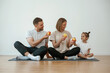 © standret - With apples in hands. Family of mother, father and daughter are doing yoga at home