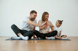 © standret - Doing high five. Family of mother, father and daughter are doing yoga at home