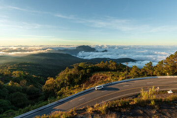 Wall Mural - top view of misty landscape with road. foggy clouds above tree.