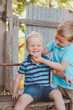 © Austockphoto - Big brother being silly making little brother smile