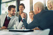 © N Hiraman/peopleimages.com - Serious, businessmen and arm wrestle in office for corporate challenge and strength contest. Male employees, team building and meeting in boardroom for corporate competition, conflict or disagreement