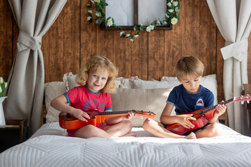 Poster - Cute sweet toddler children, tickling feet on the bed, laughing and smiling