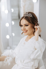 Wall Mural - A woman is sitting in a chair with a tiara on her head. She is smiling and she is happy