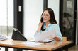 © Thitisak - Asian woman talking on smartphone with customer Business matters