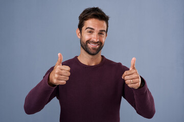 Sticker - Studio, thumbs up and man with smile, portrait and review of vote, thank you and show with gesture. Blue background, banner and person with hands, yes and sign for opinion, agreement or happy in USA