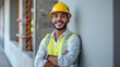 © horizon - A portrait of an attractive young Brazilian man wearing jeans and a white shirt, with a yellow construction helmet on his head standing in front view with his arms crossed.