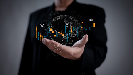 A businessman holds a virtual globe displaying currency symbols and stock market data, representing global financial markets and trading.
