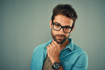 Portrait, thinking and man with ideas, glasses and problem solving on grey studio background. Face, person and model with questions, mockup space and opportunity with choice, eyewear and inspiration
