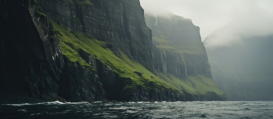 The towering sea cliffs provide a dramatic backdrop for the serene landscape in the copy space image.