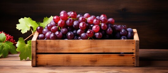 Wall Mural - Wooden box filled with fresh, ripe grapes showcasing a copy space image.