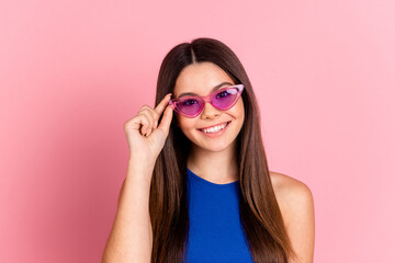 Poster - Photo of charming positive girl wear blue top arm dark glasses empty space isolated pink color background