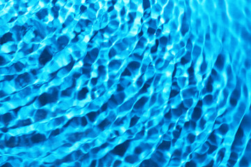 Wall Mural - Rippled surface of clear water on light blue background, closeup