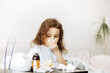 © zulfiska - Sick little kid girl sits on bed at home and blows her nose. Flu season. Healthcare concept.